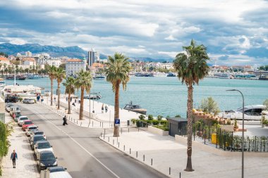 Split, Hırvatistan, 3 Ekim 2025. Adriyatik Denizi 'nde palmiye ağaçları ve turistlerle dolu bir gezinti alanı.