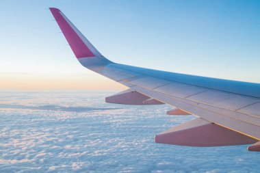 Bulutlardan oluşan bir uçaktan manzara, güzel mavi gökyüzü ve bir uçağın kanadı bir seyahatte.