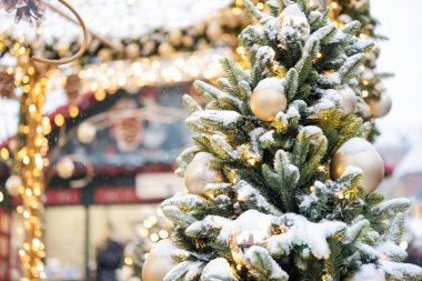 Süslü bir Noel bayrağı ve dallarında karla süslenmiş yeni yıl ağacı.