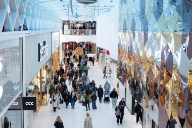 Gdansk, Polonya, 22 Kasım 2025, Forum alışveriş merkezi içinde ünlü marka arabalardan alışveriş yapan bir kalabalık var.