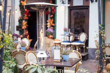 Sonbaharda bir yaz terasında ısıtıcısı olan bir kafe restoranının içinde.