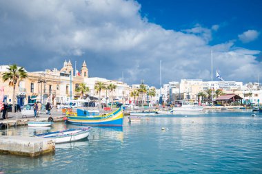 Marsaxlokk Limanı. Malta, 7 Ocak 2026. Koyun ve sahilin manzarası Denizde renkli teknelerle.
