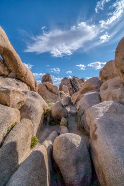 Üzerinde mavi gökyüzü olan kayalık bir kanyon. Gökyüzü açık ve güneş parlıyor.