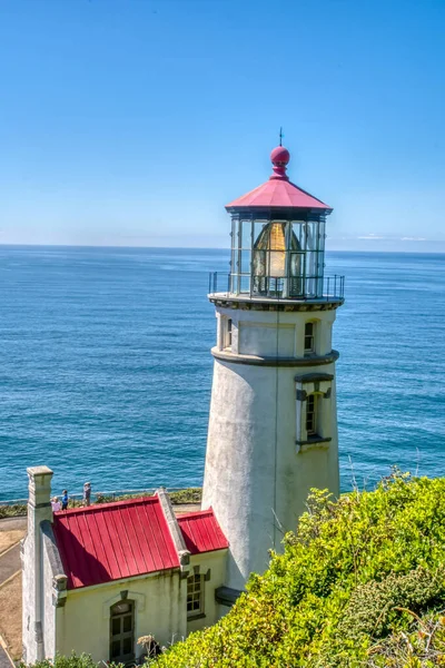 Okyanusa bakan bir tepede bir deniz feneri var. Deniz feneri beyaz ve kırmızıdır. Okyanus mavi ve sakin