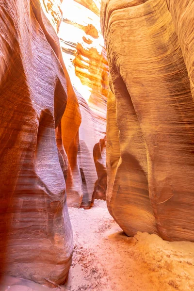 Kumlu zemini ve kırmızı kayadan duvarı olan dar bir kanyon. Kanyon dar ve duvarlar dik.
