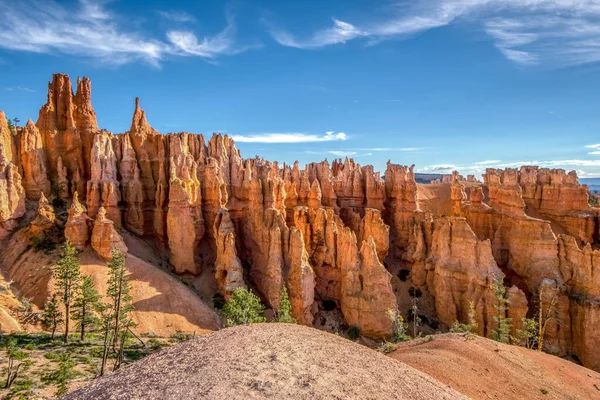 Arka planda mavi gökyüzü olan bir dağ sırası. Dağlar turuncu ve gökyüzü berrak