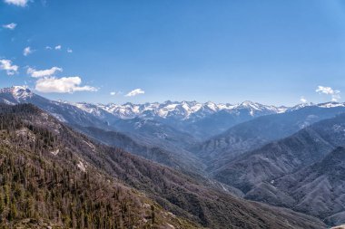 Dağlar karla kaplı ve gökyüzü berrak. Manzara nefes kesici ve huzur verici.
