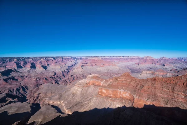 Gökyüzü mavi ve dağlar kırmızı. Dağlar çok yüksek ve gökyüzü çok berrak.