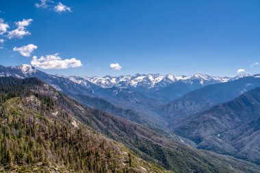 Dağlar karla kaplı ve gökyüzü berrak. Manzara nefes kesici ve huzur verici.