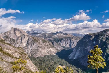 Dağlar karla kaplı ve gökyüzü mavi. Dağlar çok yüksek ve kar çok beyaz.