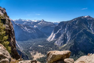 Dağlar karla kaplı ve gökyüzü açık ve mavi. Manzara nefes kesici ve huzur verici.