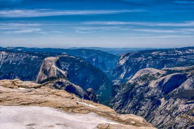 Dağlar karla kaplı ve gökyüzü mavi. Dağlar çok yüksek ve kar çok beyaz.
