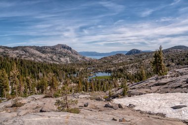 Önünde göl olan bir dağ sırası. Gökyüzü açık ve mavi. Huzurlu ve huzurlu bir sahne.