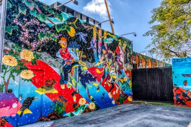 Sahnede müzik çalan bir grup insanın duvar resmi. Duvar renkli ve canlı, neşe ve yaratıcılık hissi var.