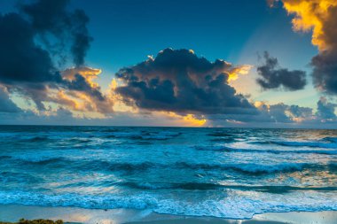 Gökyüzü mavi ve bulutlar beyaz. Güneş batıyor ve gökyüzü bulutlarla dolu.
