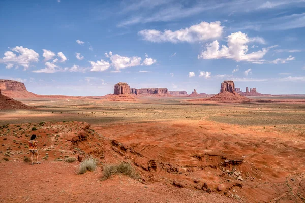 Arkasında birkaç dağ olan bir çöl manzarası. Gökyüzü açık ve mavi