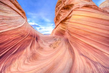 Arka planda mavi gökyüzü olan büyük bir kanyon. Kanyon kayalarla dolu ve çok fazla kir var.