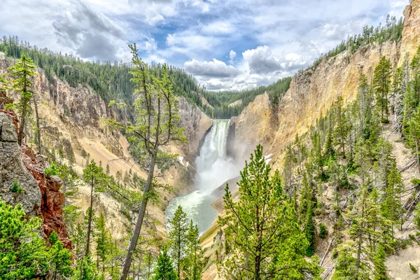 Önünde şelale olan güzel bir dağ sırası. Ağaçlar yemyeşil, gökyüzü açık ve mavidir. Huzurlu ve huzurlu bir sahne, ve huşu uyandırıyor.