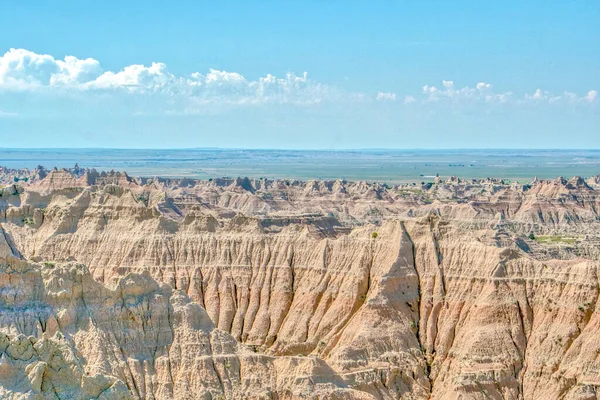 Gökyüzü mavi ve toprak kuru. Manzara çorak ve kayalık. Gökyüzü açık ve güneş parlıyor.