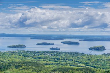 Büyük bir yolcu gemisi küçük bir adanın yakınında okyanusta yol alıyor. Gökyüzü bulutlu ama su sakin. Sahne huzurlu ve huzurlu, gemiyle.