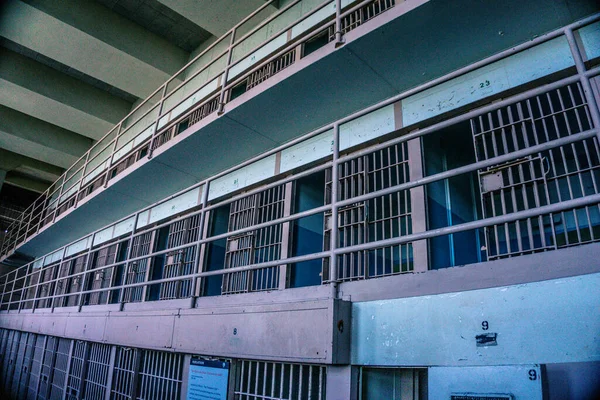 Pencere ve kapılarında parmaklıklar olan bir hapishane bloğu.