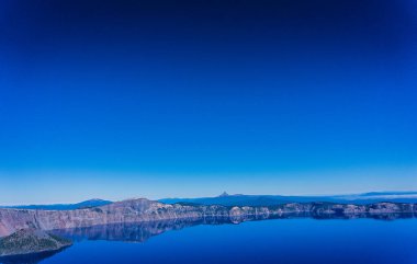 Arka planda dağlar olan güzel mavi bir gökyüzü. Gökyüzü açık ve güneş parlıyor.