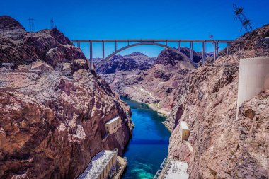 Bir köprü çöldeki bir nehri kapsar. Köprü dağlarla çevrili ve su temiz.