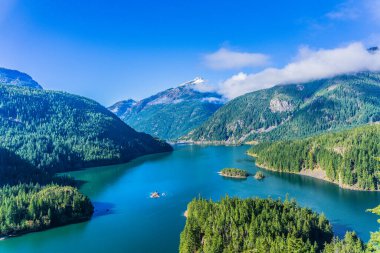 Ortasında göl olan güzel bir dağ sırası. Göl ağaçlar ve dağlarla çevrili.