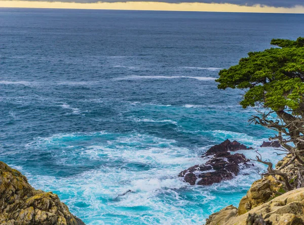 Okyanus sakin ve gökyüzü bulutlu. Su mavi ve gökyüzü gri.