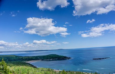Bulutları ve büyük bir su kütlesi olan güzel mavi bir gökyüzü. Gökyüzü açık ve su sakin.
