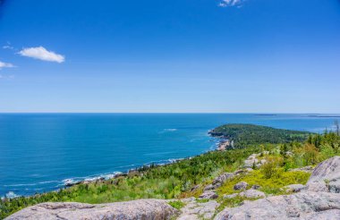 Güzel bir okyanus manzarası ve kayalık bir kıyı şeridi. Gökyüzü berrak ve mavi, ve su sakin. Sahne huzurlu ve huzurlu. Rahatlamak ve doğanın güzelliğinin tadını çıkarmak için harika bir yer.