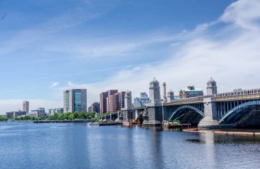 Nehir üzerinde büyük bir köprüsü olan bir şehir. Köprü yeşil ve su sakin.