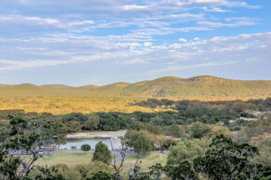 Önünde göl olan güzel bir dağ sırası. Gökyüzü açık ve mavidir, ve güneş parlıyor. Sahne huzurlu ve sakin, dağlarla birlikte.