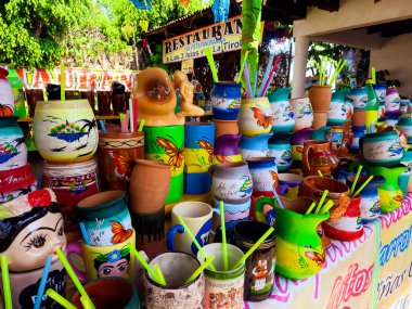 Bir masa dolusu renkli kupa ve kelebek tasarımı bardaklar. Masa bir restoranın dışında hazır.