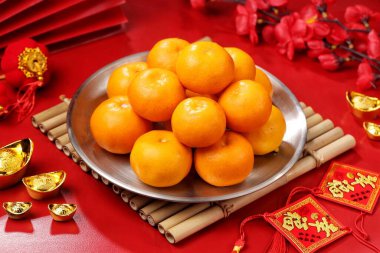 Çin Yeni Yıl süslemeleri ile gümüş tepside taze mandalina düzenlemek.