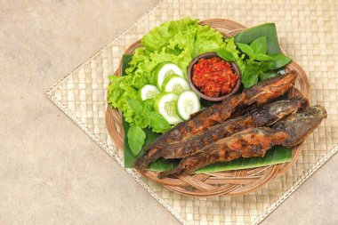 Pecel lele, kedibalığı ve domates sosundan oluşan tipik bir Doğu Java yemeğidir..