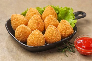 Marul yapraklarıyla hazırlanmış bir tabak altın kızartma..