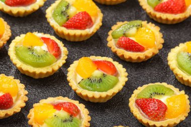 Meyveli turtalar, ekmekler ve kek ürünleri. Karakteristik çıtır çıtır, tuzlu ve tuzlu. Üstünde çeşitli meyveler var..