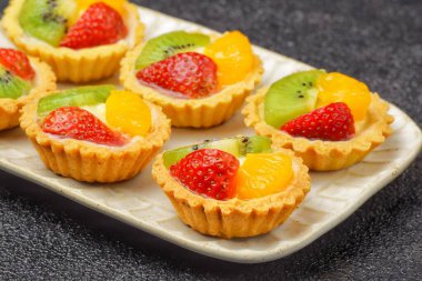 Meyveli turtalar, ekmekler ve kek ürünleri. Karakteristik çıtır çıtır, tuzlu ve tuzlu. Üstünde çeşitli meyveler var..