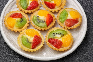 Meyveli turtalar, ekmekler ve kek ürünleri. Karakteristik çıtır çıtır, tuzlu ve tuzlu. Üstünde çeşitli meyveler var..