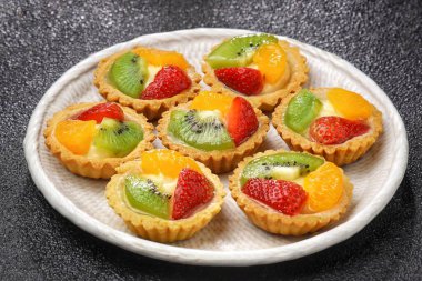 Meyveli turtalar, ekmekler ve kek ürünleri. Karakteristik çıtır çıtır, tuzlu ve tuzlu. Üstünde çeşitli meyveler var..