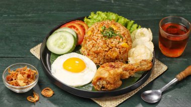 Nasi goreng. Kızarmış pilav, sahanda yumurta ve yanında salatalık ve domates dilimlenmiş salatalık.