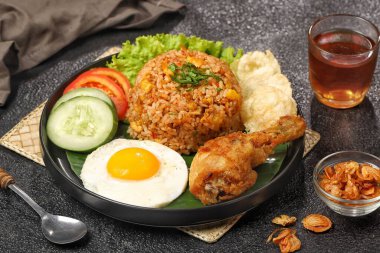 Nasi goreng. Kızarmış pilav, sahanda yumurta ve yanında salatalık ve domates dilimlenmiş salatalık.