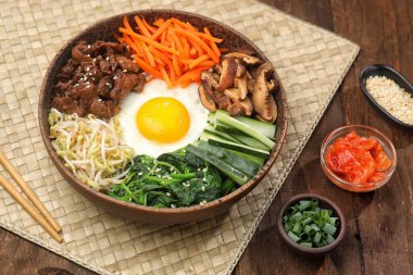Bibimbap, yanında sebze, biftek, yumurta ve baharatlı gochujang sosu bulunan bir kase beyaz pirinç şeklinde bir Kore yemeğidir..