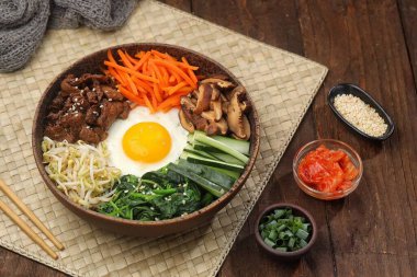 Bibimbap, yanında sebze, biftek, yumurta ve baharatlı gochujang sosu bulunan bir kase beyaz pirinç şeklinde bir Kore yemeğidir..