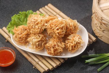 Masadaki tabakta kızartılmış erişte.