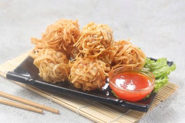 Masadaki tabakta kızartılmış erişte.