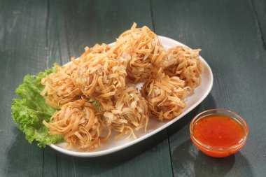 Masadaki tabakta kızartılmış erişte.