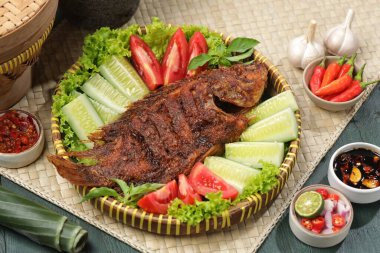 Ikan Bakar, taze salatalık ve domatesle servis edilen Endonezya usulü ızgara tilapia balığı.