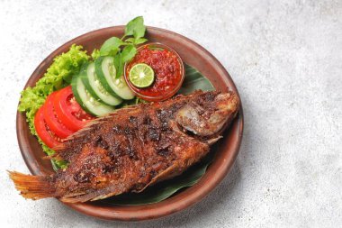Ikan Bakar, taze salatalık ve domatesle servis edilen Endonezya usulü ızgara tilapia balığı.